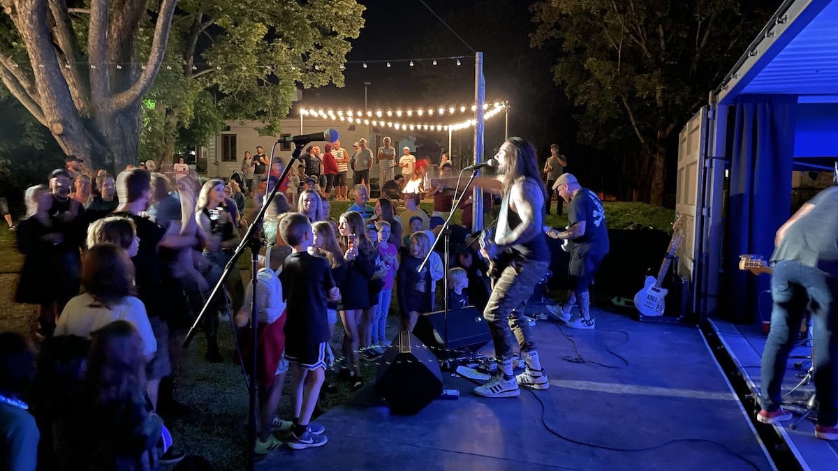 Concert rock sur la scène conteneur, public familial au premier rang