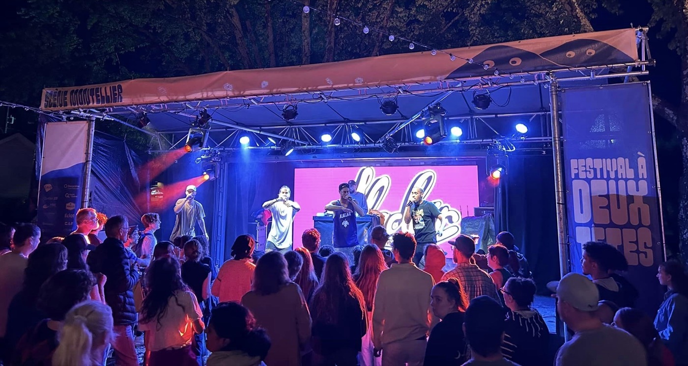 Scène Montellier de nuit — artistes et foule sous les projecteurs
