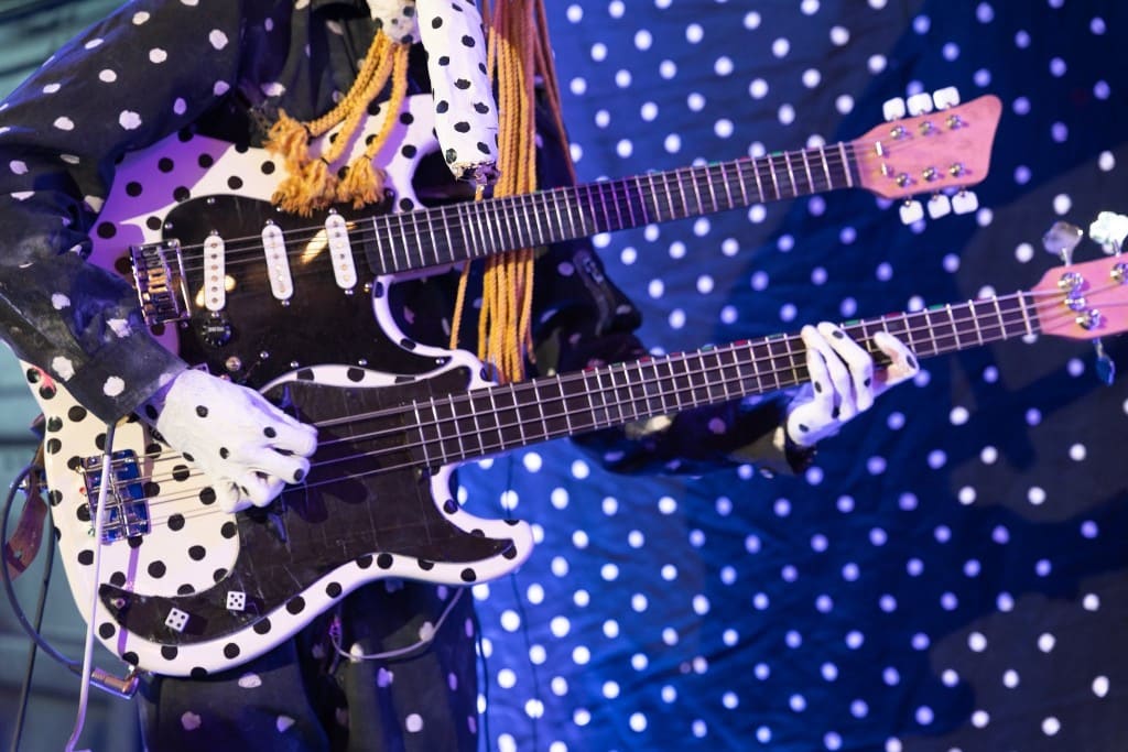 Musicien en costume à pois jouant d'une guitare double manche