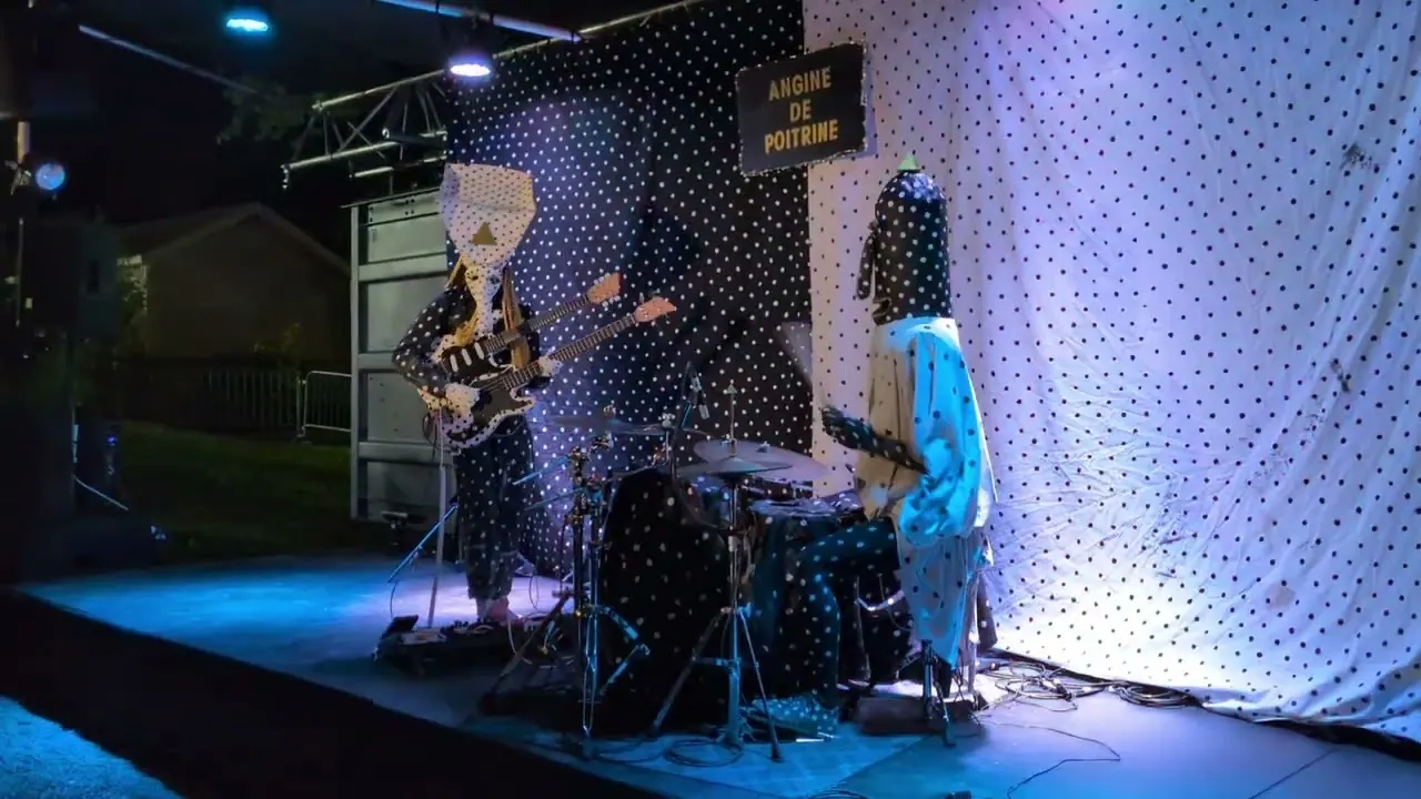 Angine de Poitrine sur scène : costumes à pois et guitare double manche