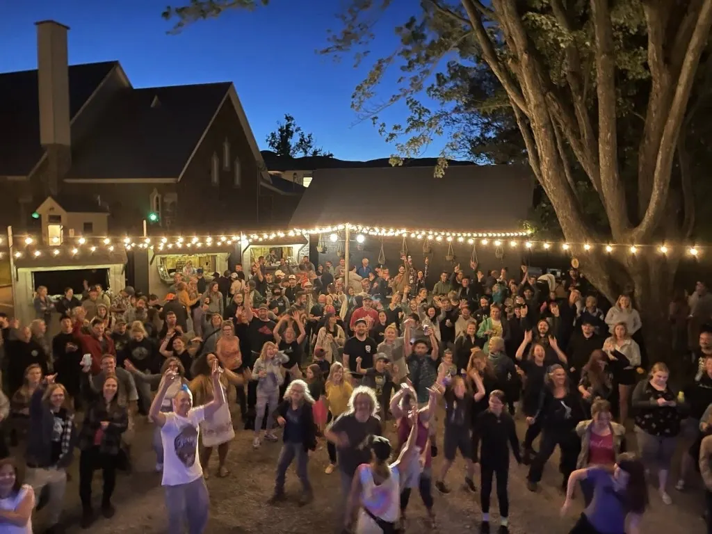 Cour du village festivalier : foule, guirlandes et kiosques de service
