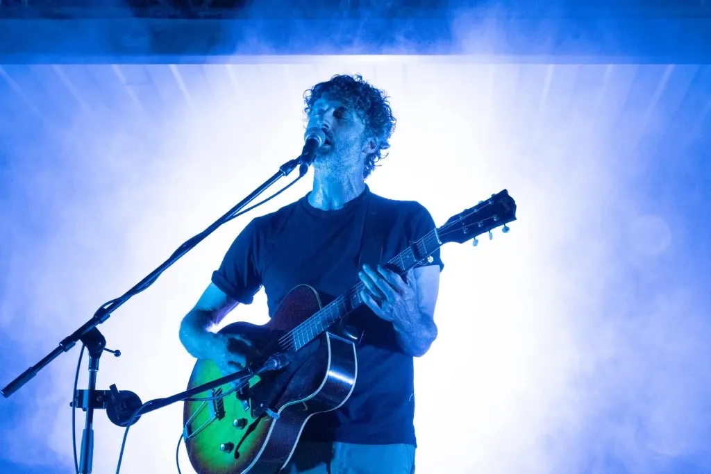 Guitariste-chanteur en spectacle sous une lumière bleue