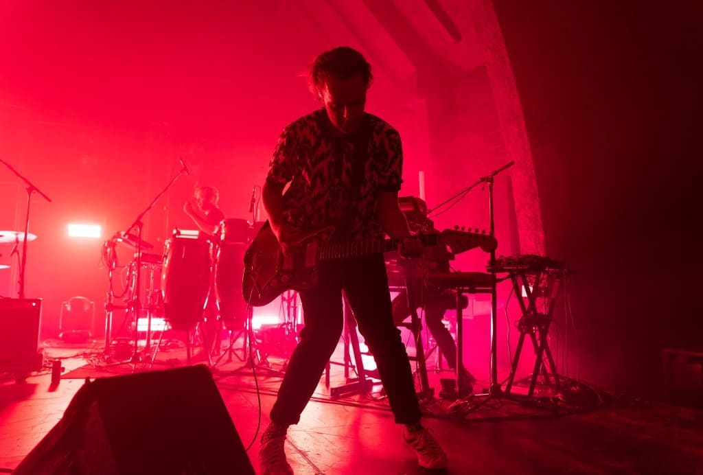 Guitariste en spectacle sous une lumière rouge intense