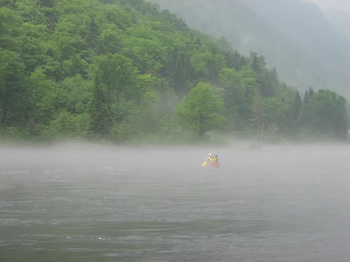 Canot dans la brume au pied des montagnes de la Jacques-Cartier