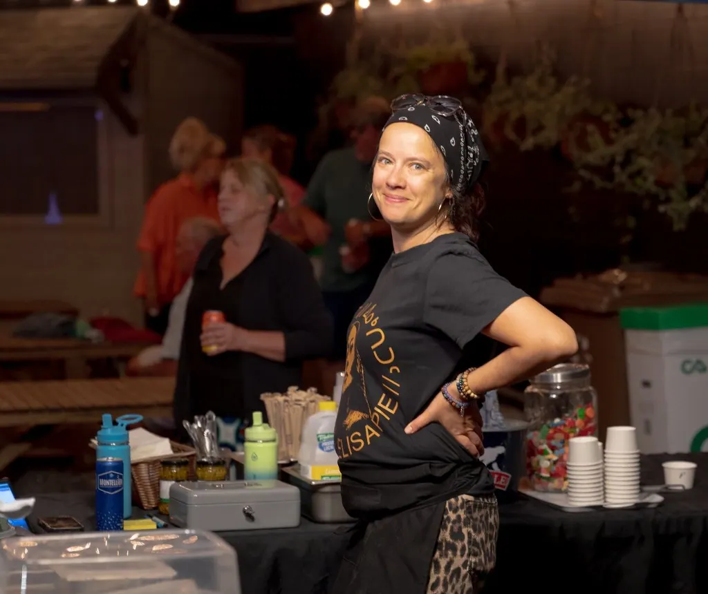Bénévole souriante derrière le comptoir