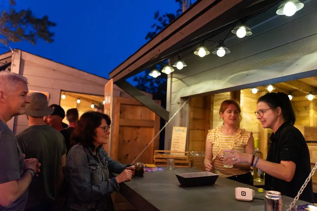 Bénévoles au kiosque, soirée festive sous les guirlandes